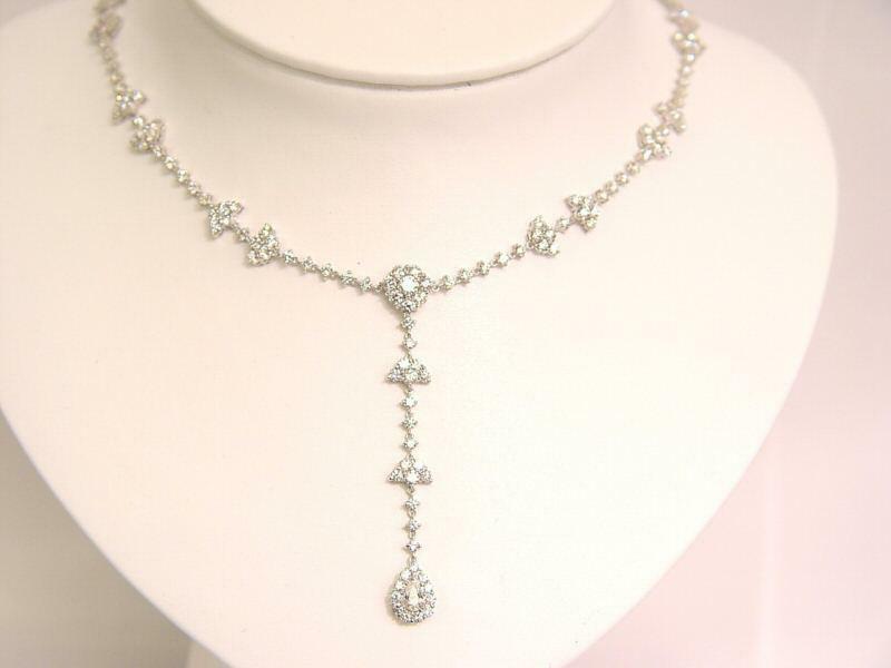 10.05 CTTW ROUND BRILLIANT CUT AND 1 PEAR CUT .38 CT SET IN THE CENTER DIAMOND