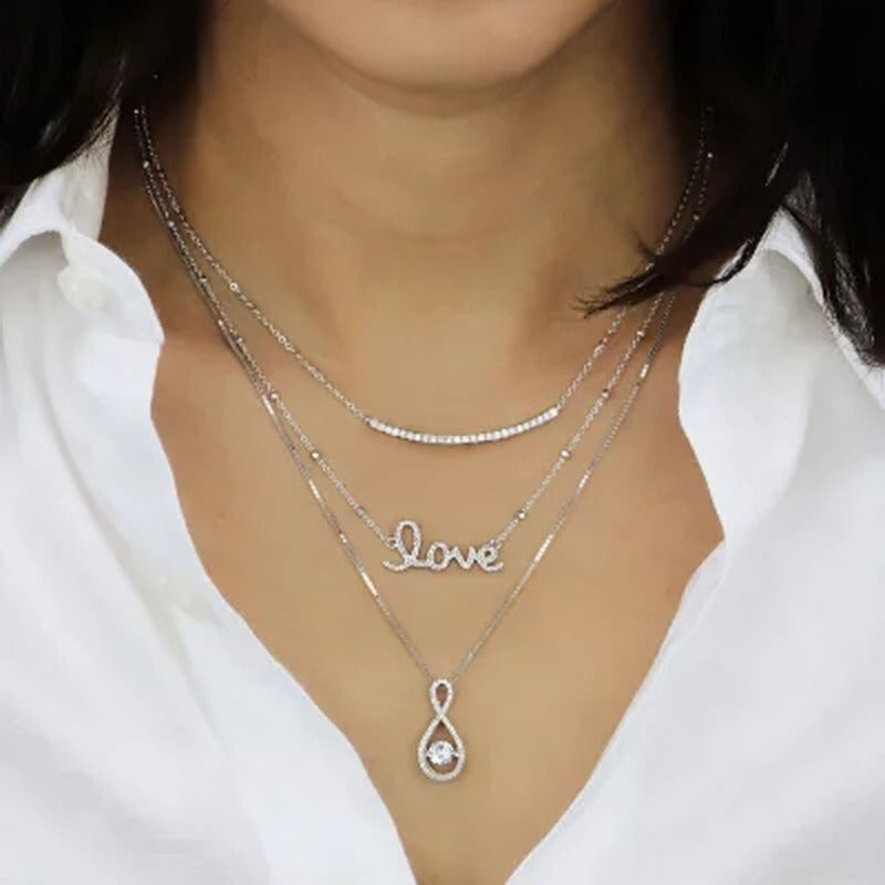 Dancing Lab Created White Sapphire and 0.12 CT. T.W. Diamond Infinity Pendant in