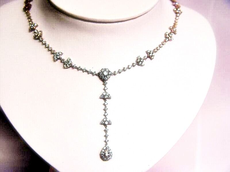 10.05 CTTW ROUND BRILLIANT CUT AND 1 PEAR CUT .38 CT SET IN THE CENTER DIAMOND